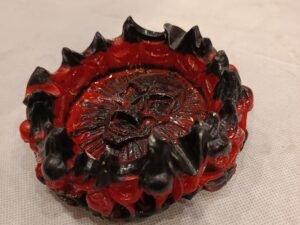 Cendrier gothique circulaire noir et rouge agrémenté de crânes en pourtour et au centre du cendrier