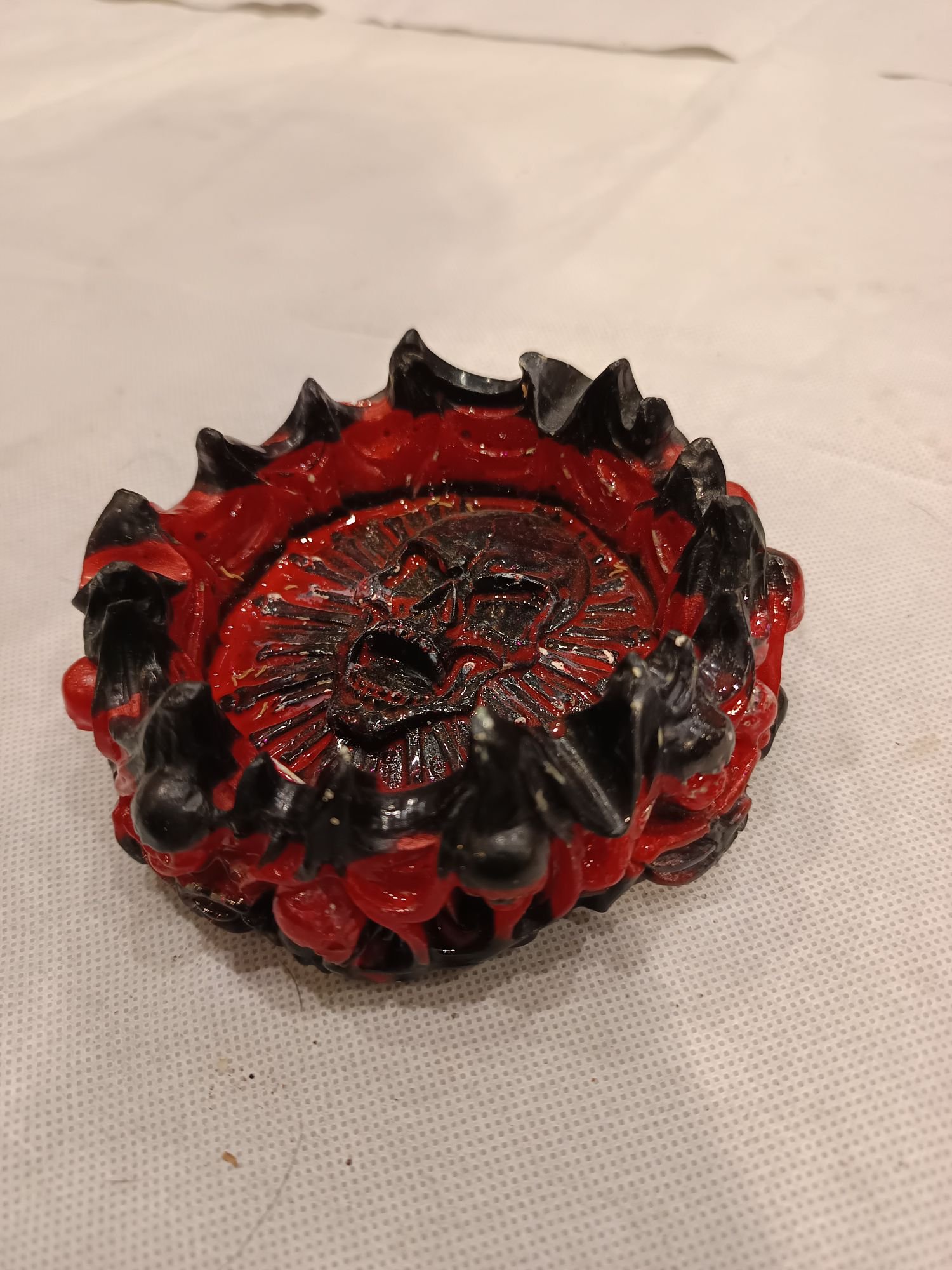 Cendrier gothique circulaire noir et rouge agrémenté de crânes en pourtour et au centre du cendrier